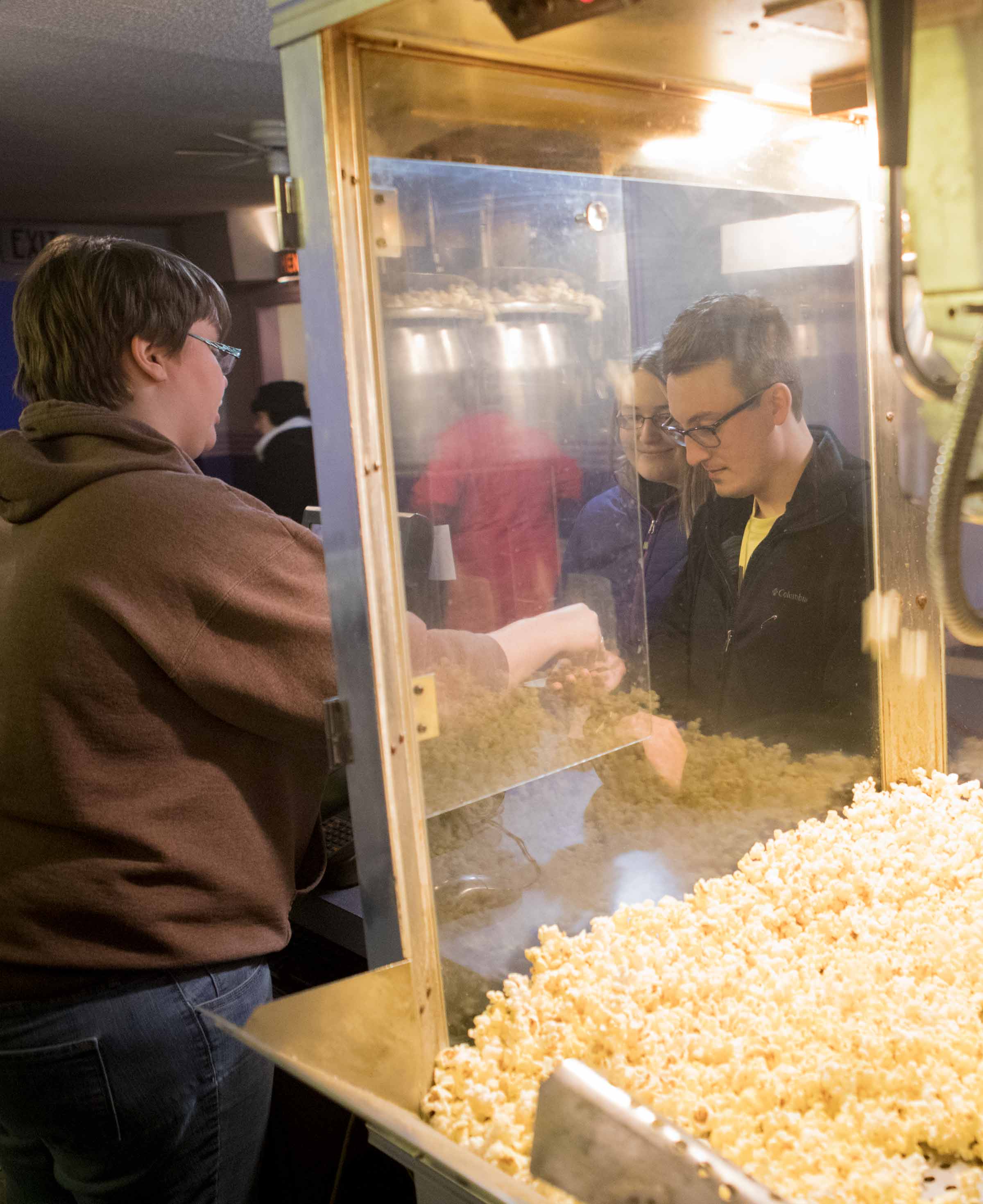 Fifth-year pharmacy student Caitlin Nahirniak and Andy Kremyar, a 2015 Ohio Northern University graduate, buy concessions before the start of a free screening of the movie “Friday Night Lights” at Ada Theatre.