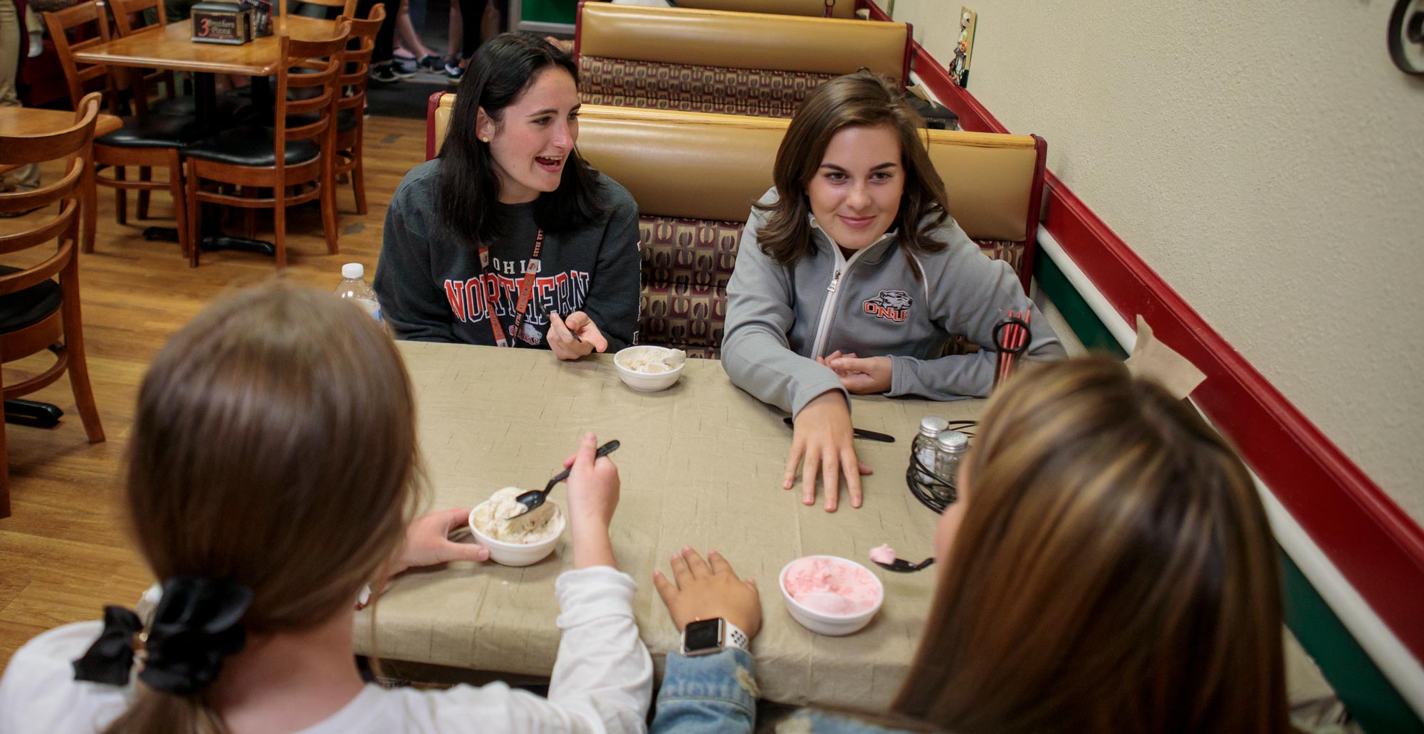 From left, first-year pharmacy student Denise Williams and freshman Isabella Orofino talk and eat ice cream at Three Brothers Pizza. 