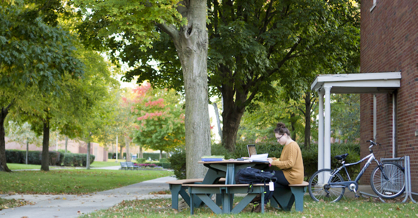 law student outside fall leaves