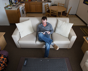 Photo of ONU student in Courtyard Apartments reading a book