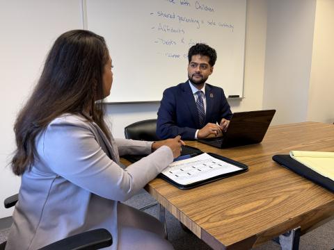 An ONU law student reviewing legal documents with a client in an office setting.