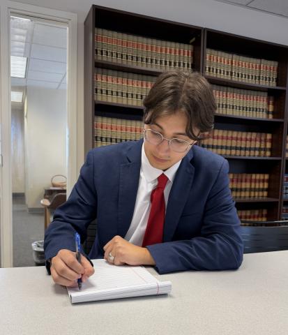 Extern reviewing legal documents at a desk